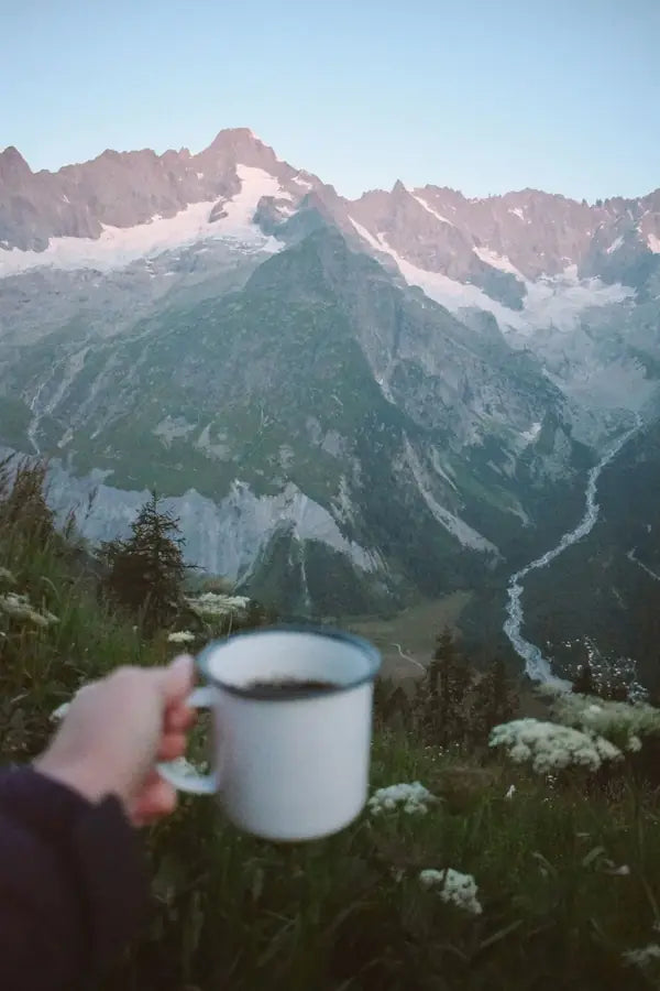 Une tasse émaillée au-dessus d'une vallée