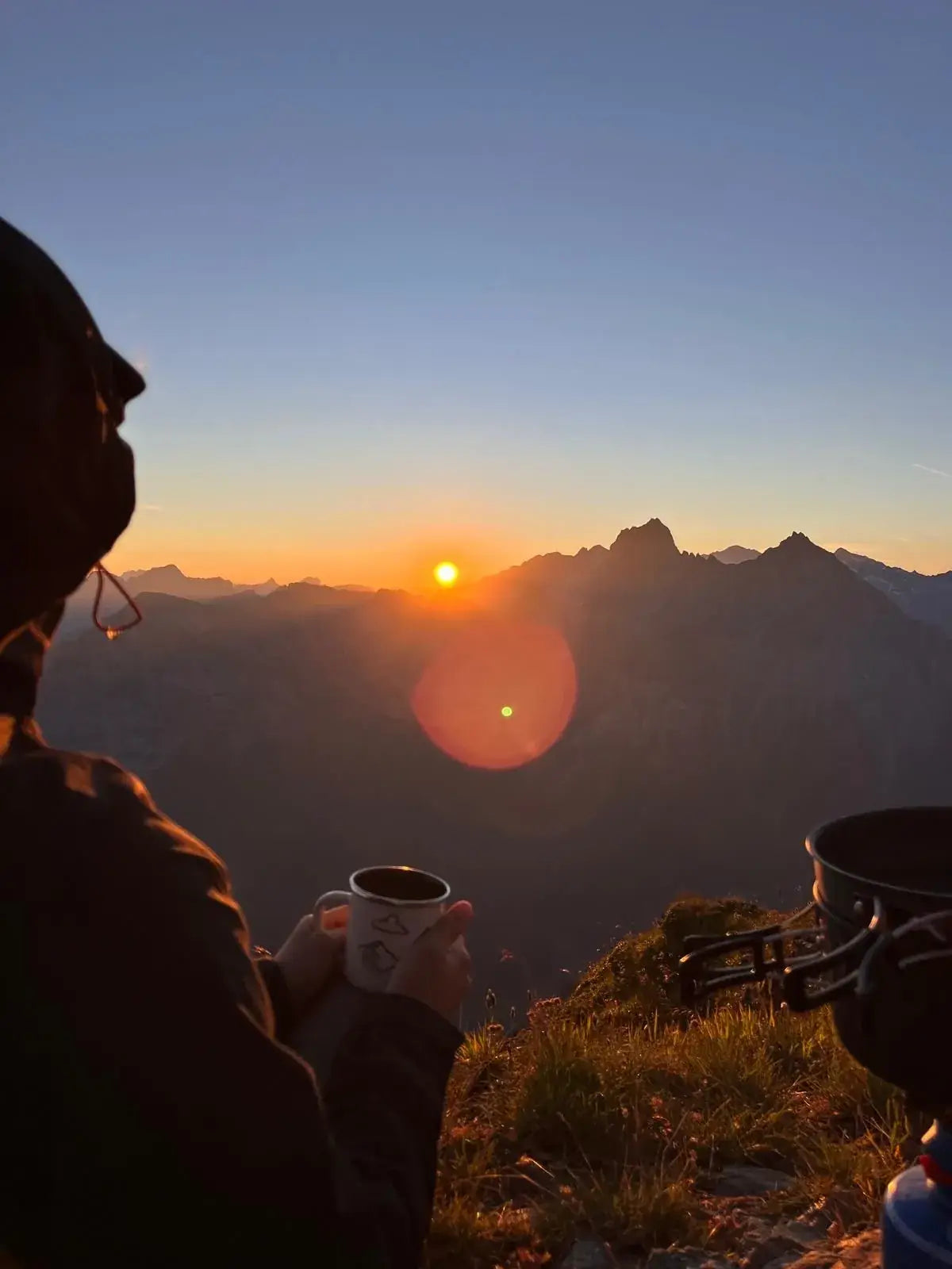 Lever de soleil sur les crêtes, une tasse chaude dans la main