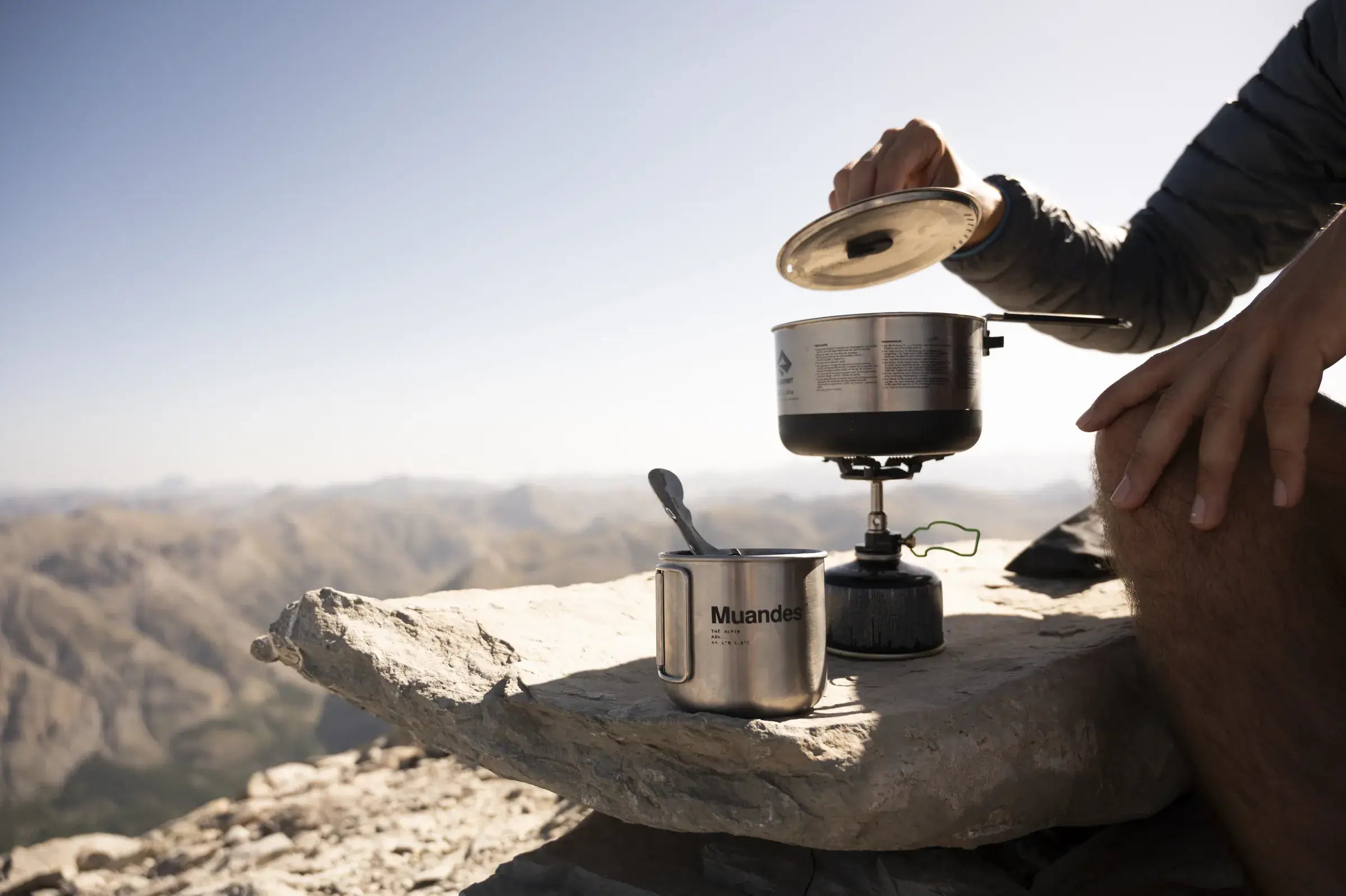 Un réchaud et une tasse Muandes sur un rocher en altitude