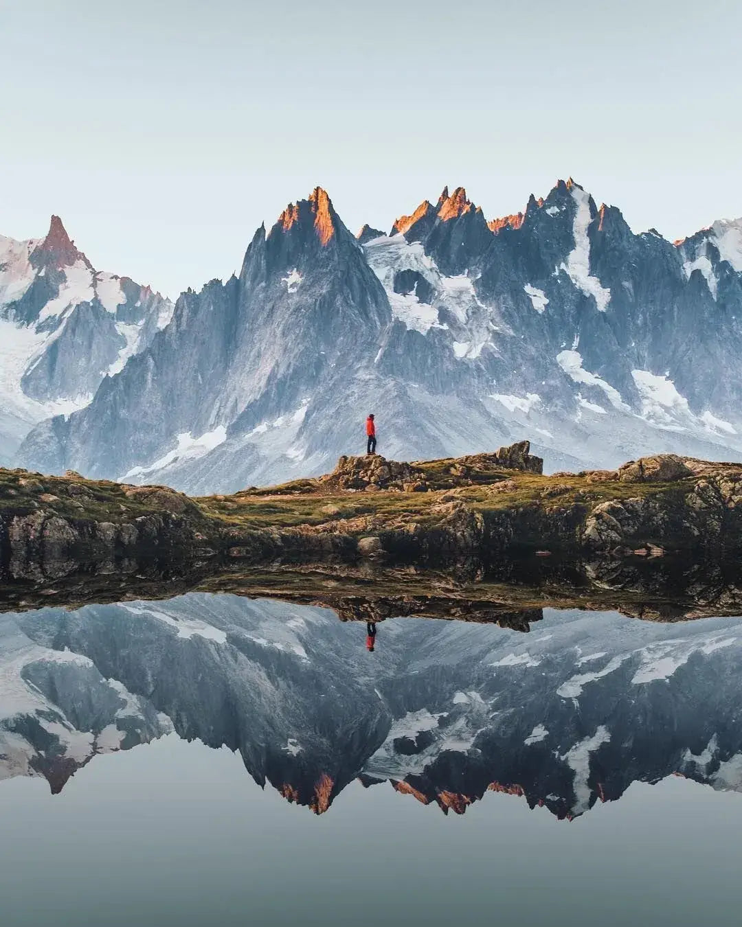 Des sommets enneigés qui se reflètent dans un lac d'altitude